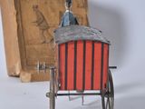 a small toy horse drawn carriage next to an old book