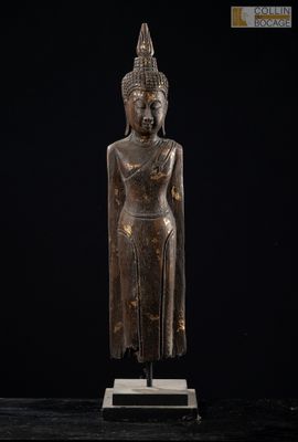 une statue en bronze représentant une personne sur fond noir