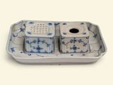 une assiette bleue et blanche sur laquelle sont posés deux salières et poivrières