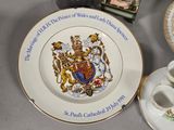 a plate with a coat of arms on it next to a cup and saucer