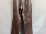 a pair of brown leather pants hanging on a hanger
