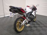 a red and white motorcycle parked on a black and white checkered floor