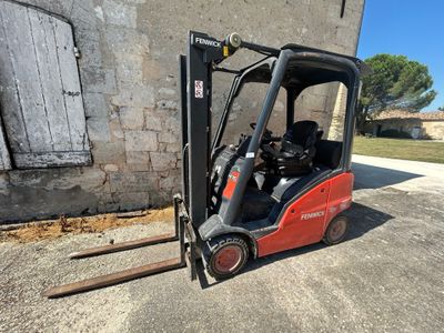 un chariot élévateur rouge garé devant un immeuble