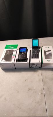 Plusieurs téléphones portables sont posés sur une table, à côté de boîtes qui en contiennent d'autres.