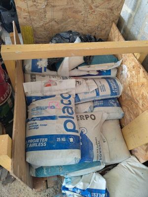 a wooden box filled with bags of cement next to a pile of bags