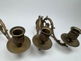 three brass candlesticks on a white background