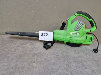 un gros plan d'un souffleur de feuilles vert posé sur une table