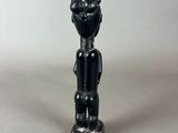 a black figurine of a man with a hat on his head