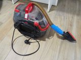 a vacuum that is sitting on the floor next to a brush