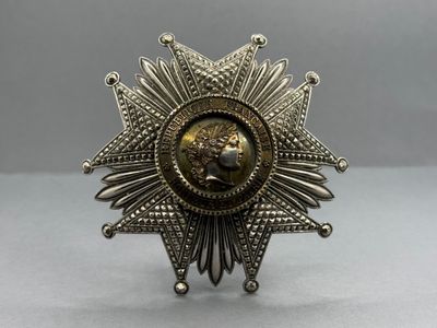 un gros plan d'une broche en argent et en or posée sur une table