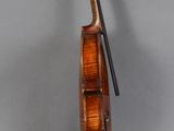 an old violin sitting on top of a wooden stand