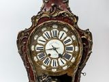 a clock that is sitting on a stand with a bird on it