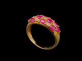 une bague en or sertie de pierres roses sur fond noir