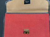 a close up of a red and blue purse on a black surface