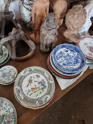 une table sur laquelle sont disposées de nombreuses assiettes et figurines