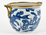 un vase bleu et blanc muni d'une anse dorée