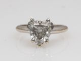 a heart shaped diamond ring on a white surface