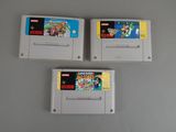 trois cartouches de jeux nintendo posées sur une table