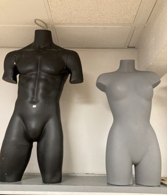 deux mannequins assis côte à côte sur une étagère