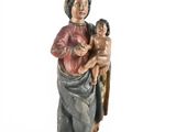 une statue ancienne d'une femme tenant un enfant dans ses bras