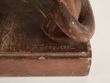 a wooden sculpture of a man with a hat on his head