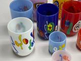 many cups with different designs on them on a white surface