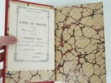 a hand holding a book with a red cover