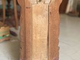 a small wooden clock sitting on the floor in a room