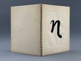 an open book with the letter n on it sitting on top of a table