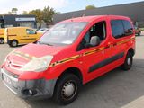 a red van that is parked in a parking lot