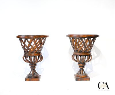 une paire de vases en bois sculpté posés sur des socles, sur fond blanc