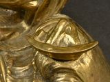 gold statue of a man with a hat on his head holding a tray