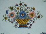 a blue and yellow plate with flowers in a basket