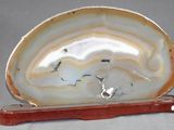 une agate blanche et brune posée sur un socle en bois
