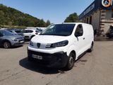 la camionnette blanche est garée devant un bâtiment dans un parking