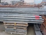 de nombreux tas de barres d'acier empilées sur des palettes