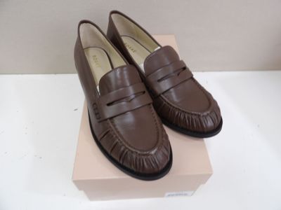 Il s'agit de deux paires de mocassins marron dans une boîte rose.