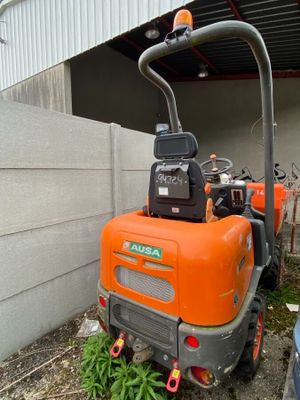 une petite machine orange garée devant un immeuble