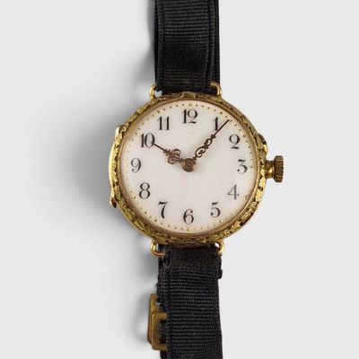 a close up of a watch on a white surface