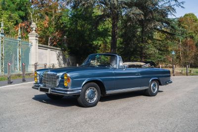 a blue car that is driving down the street
