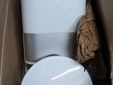 a toilet in a cardboard box with a trash can in it