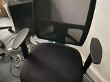 a black office chair sitting in a corner of a room
