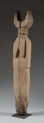 une vieille statue en bois d'un homme avec un chapeau sur la tête