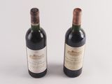two bottles of wine sitting next to each other on a white surface