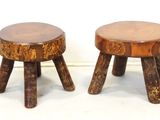 pair of small wooden stools with wooden legs on a white surface