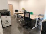 une pièce équipée d'un bureau, d'une imprimante et d'un photocopieur
