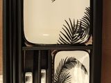 a black and white tray with a mirror and a tray with a palm leaf design