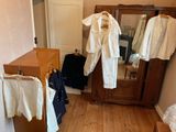 an image of a room with clothes hanging on a clothes rack
