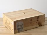 une boîte en bois portant une étiquette, posée sur un parquet