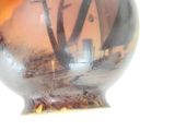 a vase that has a picture of a house on it